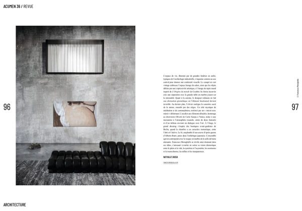 doppia pagina Acumen: dettaglio del living del Loft Industriale con divano nero, opera d’arte e testo dell’articolo