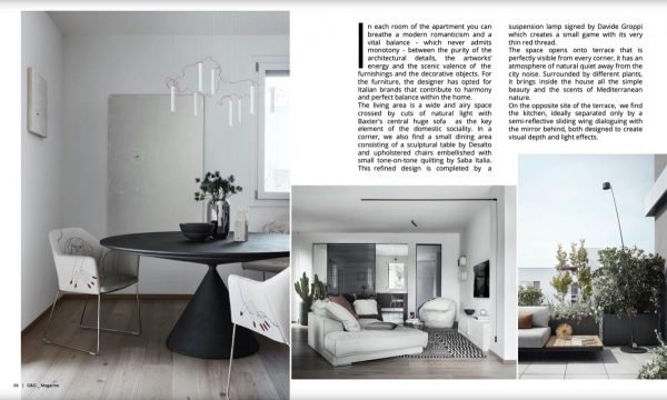 pagina G&G Magazine: tavolo rotondo nero e zona living dell’Attico Contemporaneo a Bologna, con terrazza e vegetazione
