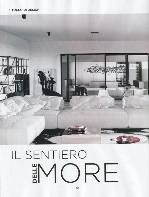 opening page of GAP CASA feature, minimal living room with a large white sofa and metal-framed glazing in the “Il sentiero delle more” project