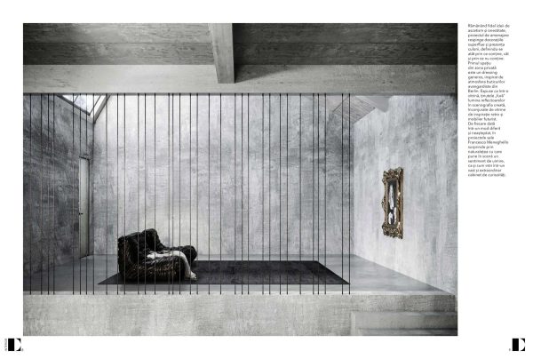 mezzanino con griglia di tondini neri, poltrona e opera in cornice dorata in ambiente brutalista