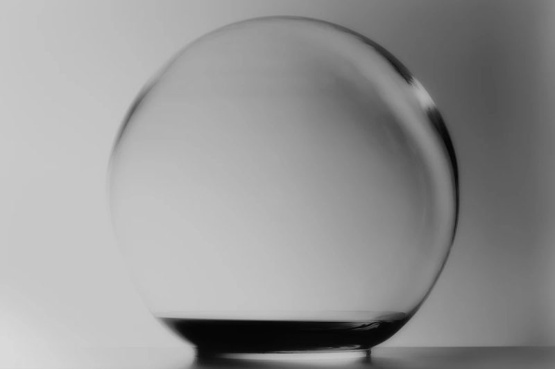 perfect transparent crystal sphere containing a small amount of black essence at the bottom.