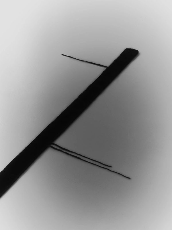 tappeto tessile nero in composizione dinamica diagonale con fili sottili incrociati