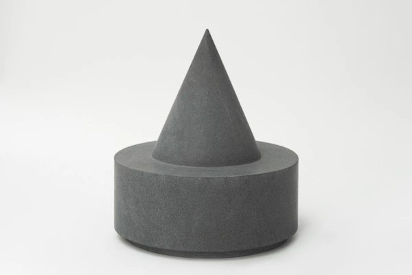 sgabello scultoreo grigio scuro in pietra lavica composto da una spessa base cilindrica da cui emerge un cono appuntito al centro