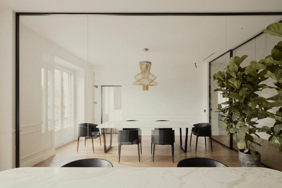 sala riunioni con grandi vetrate, tavolo minimalista in marmo, lampadario di design dorato, piante decorative