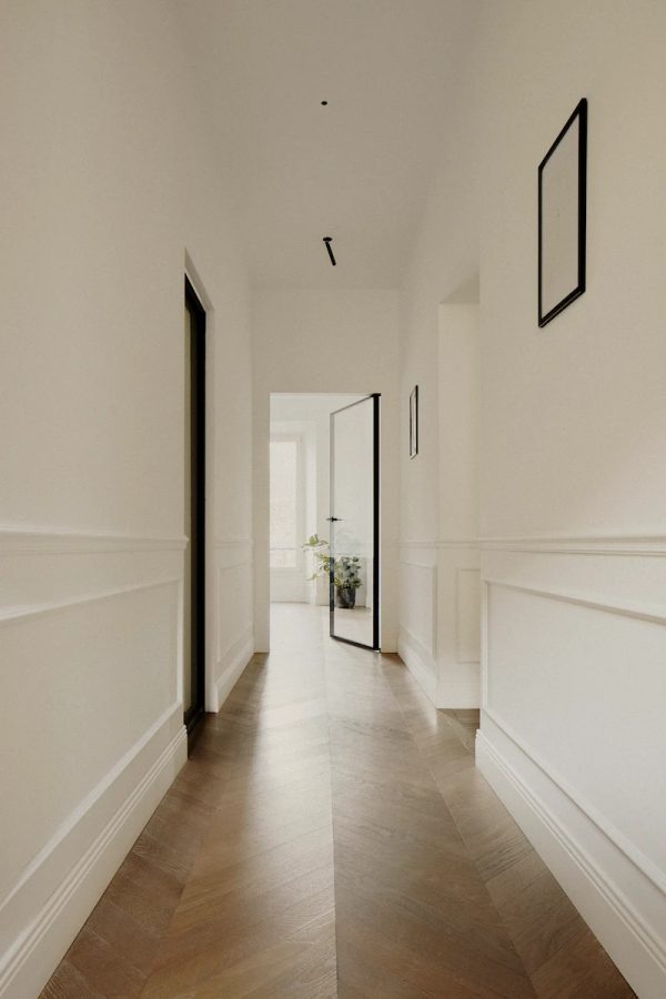 corridoio con quadri moderni alle pareti, porta in vetro moderna e pianta decorativa, dettagli classici