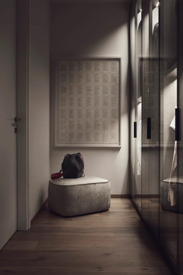 angolo guardaroba con armadi a vetri, un pouf imbottito e una borsa nera, illuminato da luce soffusa