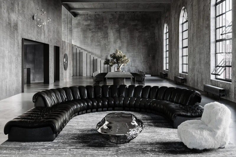 spacious industrial concrete loft with a semicircular leather sofa, sculptural metal table, and white fur armchair