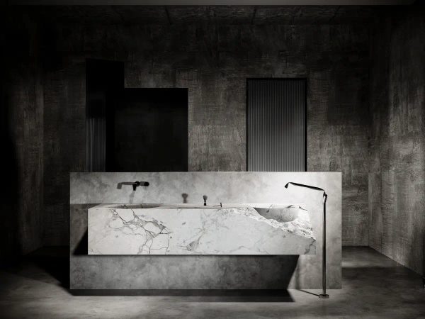 marble bathroom illuminated by dramatic lighting that highlights the various natural finishes