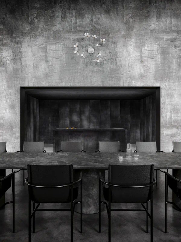 sala da pranzo industriale con tavolo in pietra e sedie minimal in pelle nera, finestre ad arco
