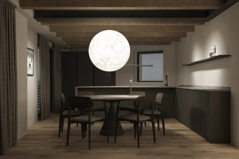 A modern mountain dining room with round table, dark wood chairs, and illuminated designer chandelier