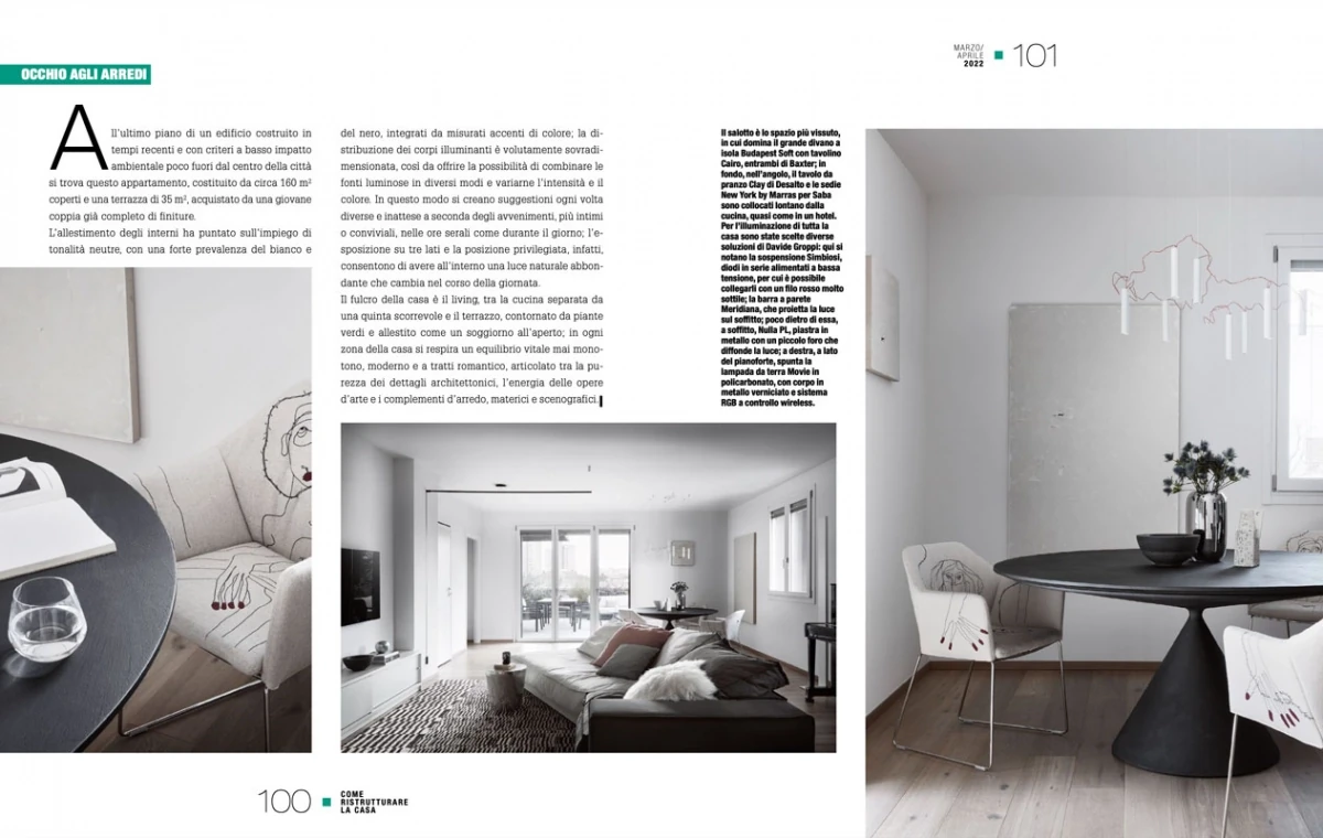double-page spread from Come Ristrutturare la Casa April 2022, dining and living areas of the Bologna penthouse with black round table and terrace view