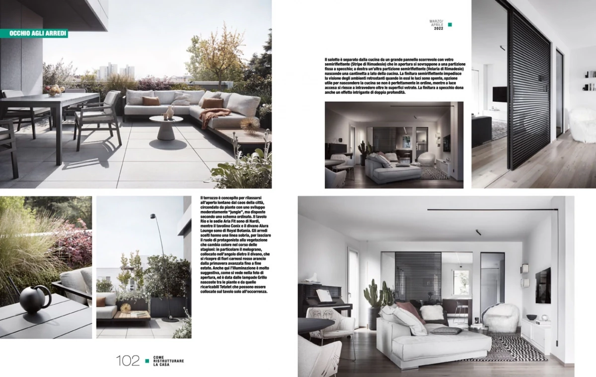 page from Come Ristrutturare la Casa April 2022, living room with light sofa and black slatted wall, terrace in daylight