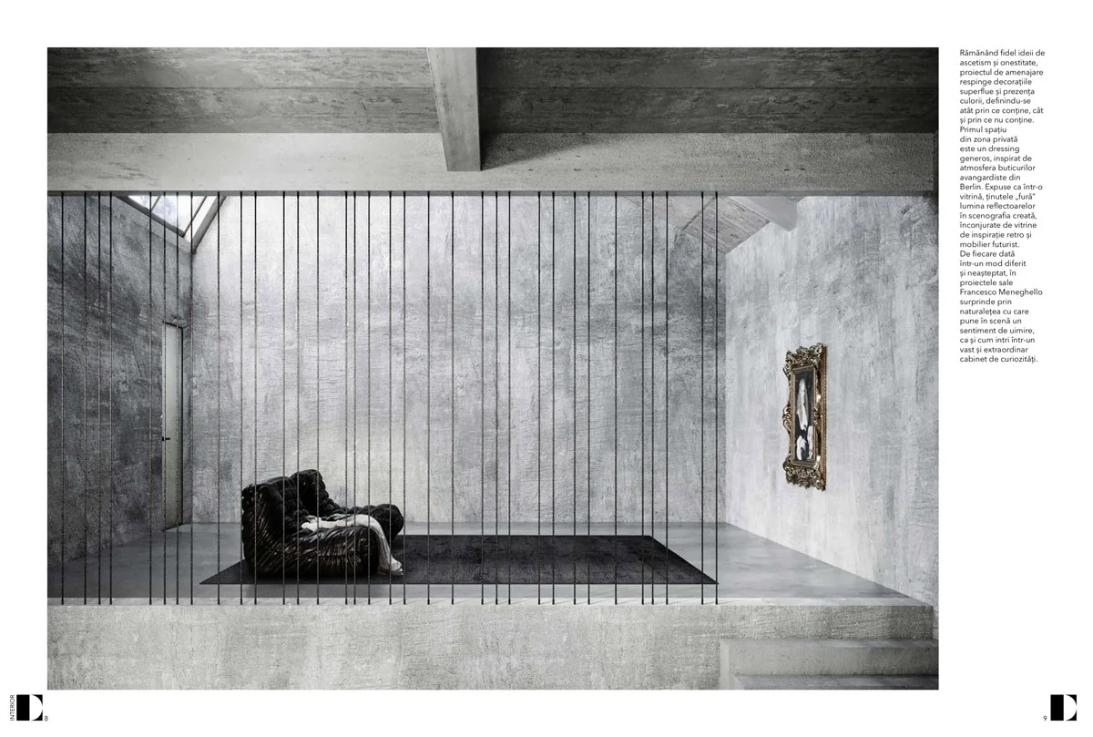 mezzanine with thin black rods, an armchair and a gilded framed artwork in a brutalist setting