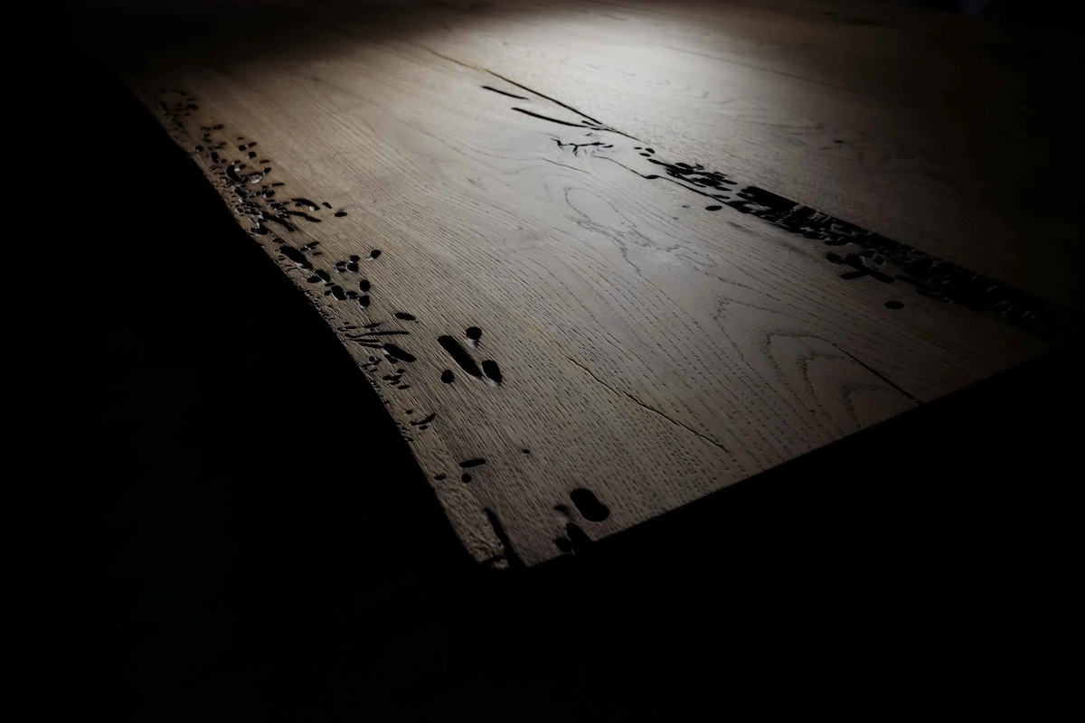 primo piano di lavabo rotondo in acciaio nero, rubinetteria a parete e LED blu d’accento