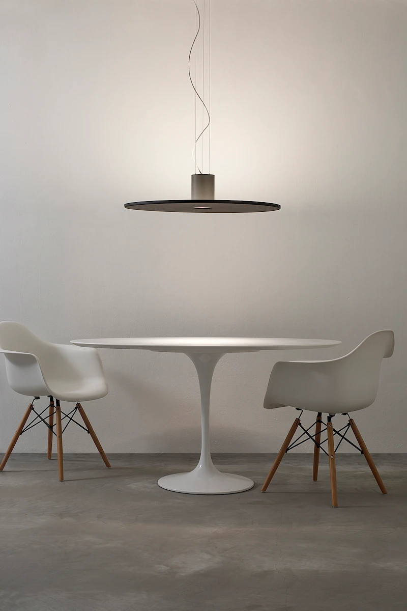 lampada a sospensione circolare con finitura nera e design minimalista, su tavolo rotondo