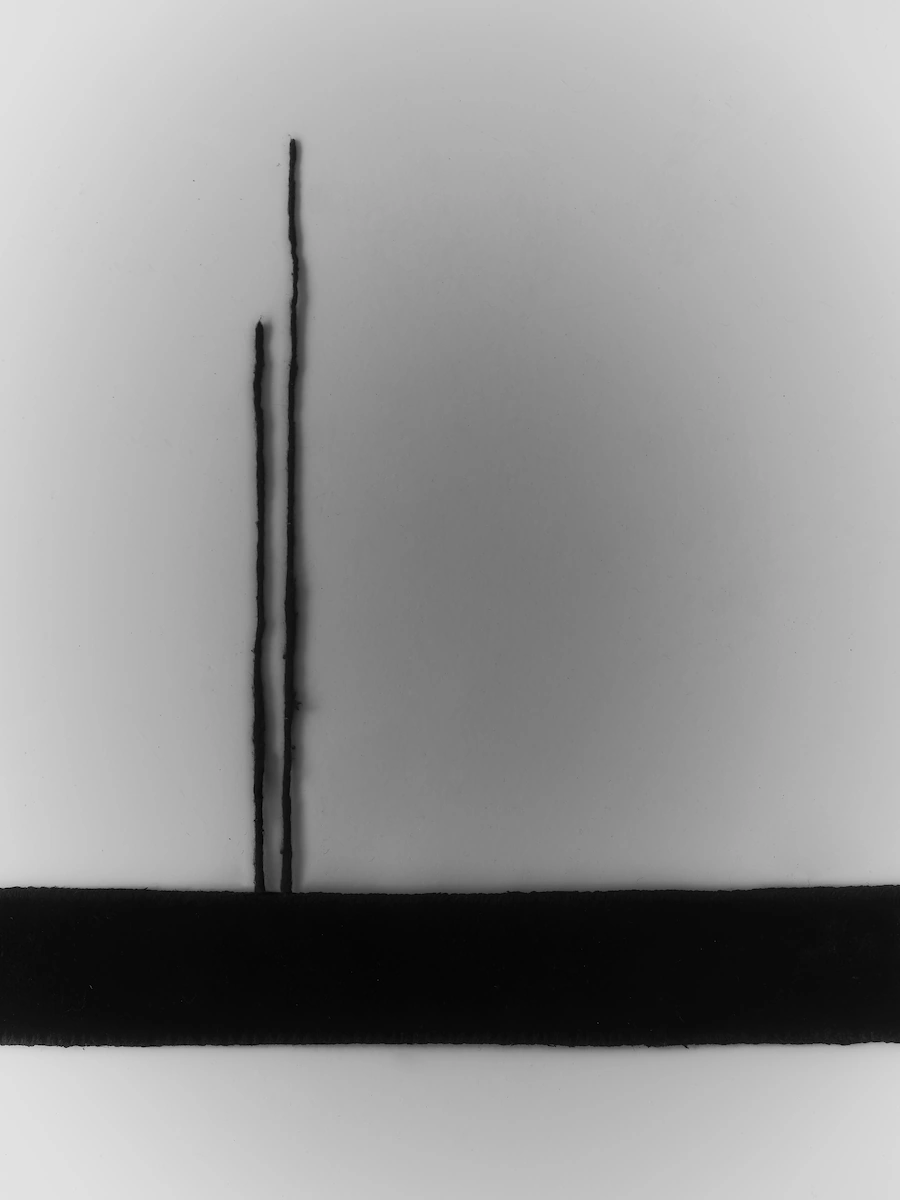 spugna naturale su tavolino nero minimal in metallo, in un ambiente moderno con pareti grigie