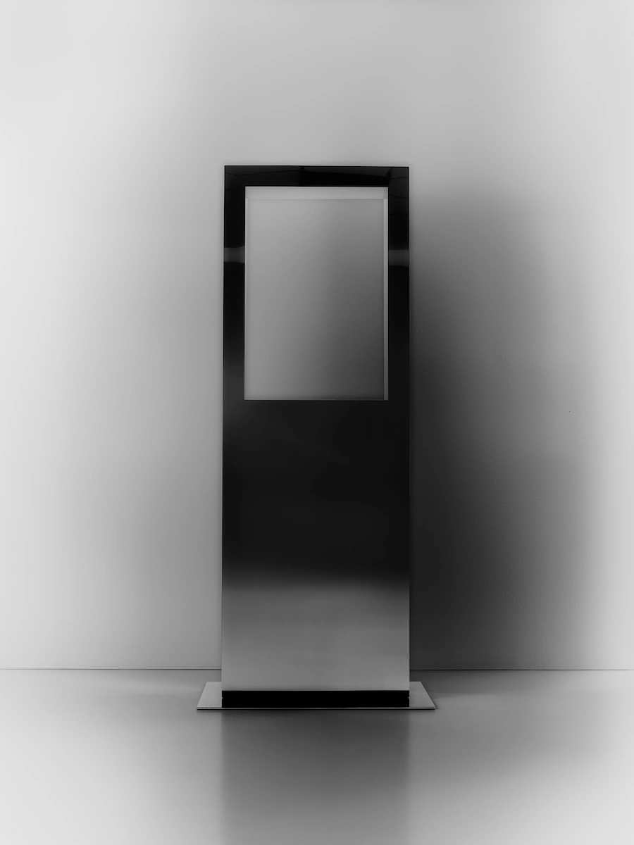 spugna naturale su tavolino nero minimal in metallo, in un ambiente moderno con pareti grigie