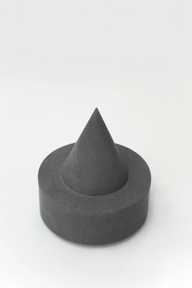 spugna naturale su tavolino nero minimal in metallo, in un ambiente moderno con pareti grigie