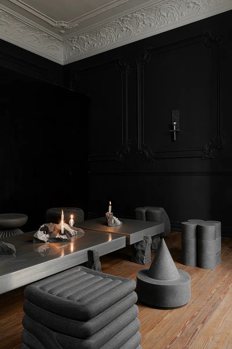 dettaglio di mensola con accessori bagno di lusso e asciugamani neri su parete grigia